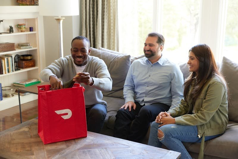 عطر الفرمون وحل مشكلة الفتور الجنسي three people sitting on a couch with a red bag